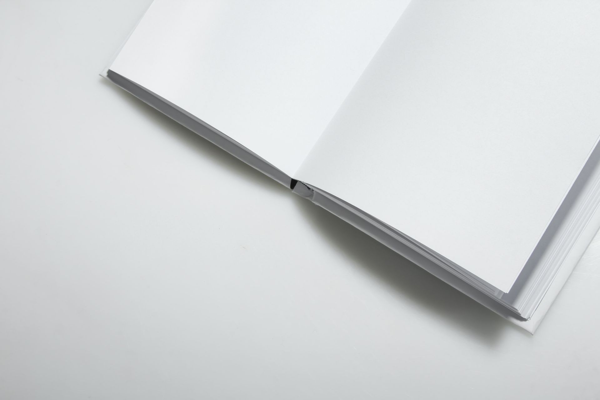 Open empty white book on a gray background. Open empty white book on a gray background.